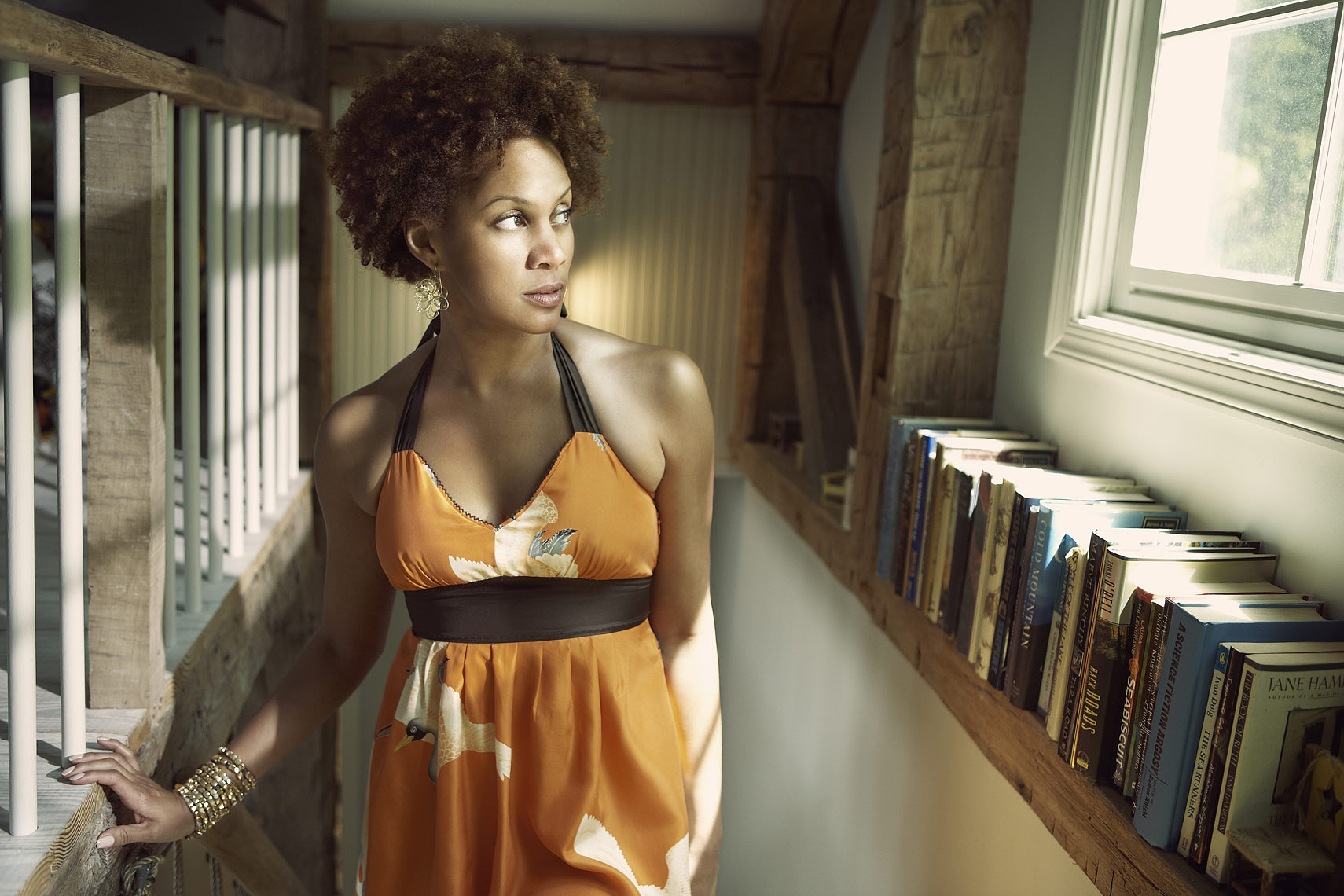 Black woman in orange Anthropologie dress walking up stairs