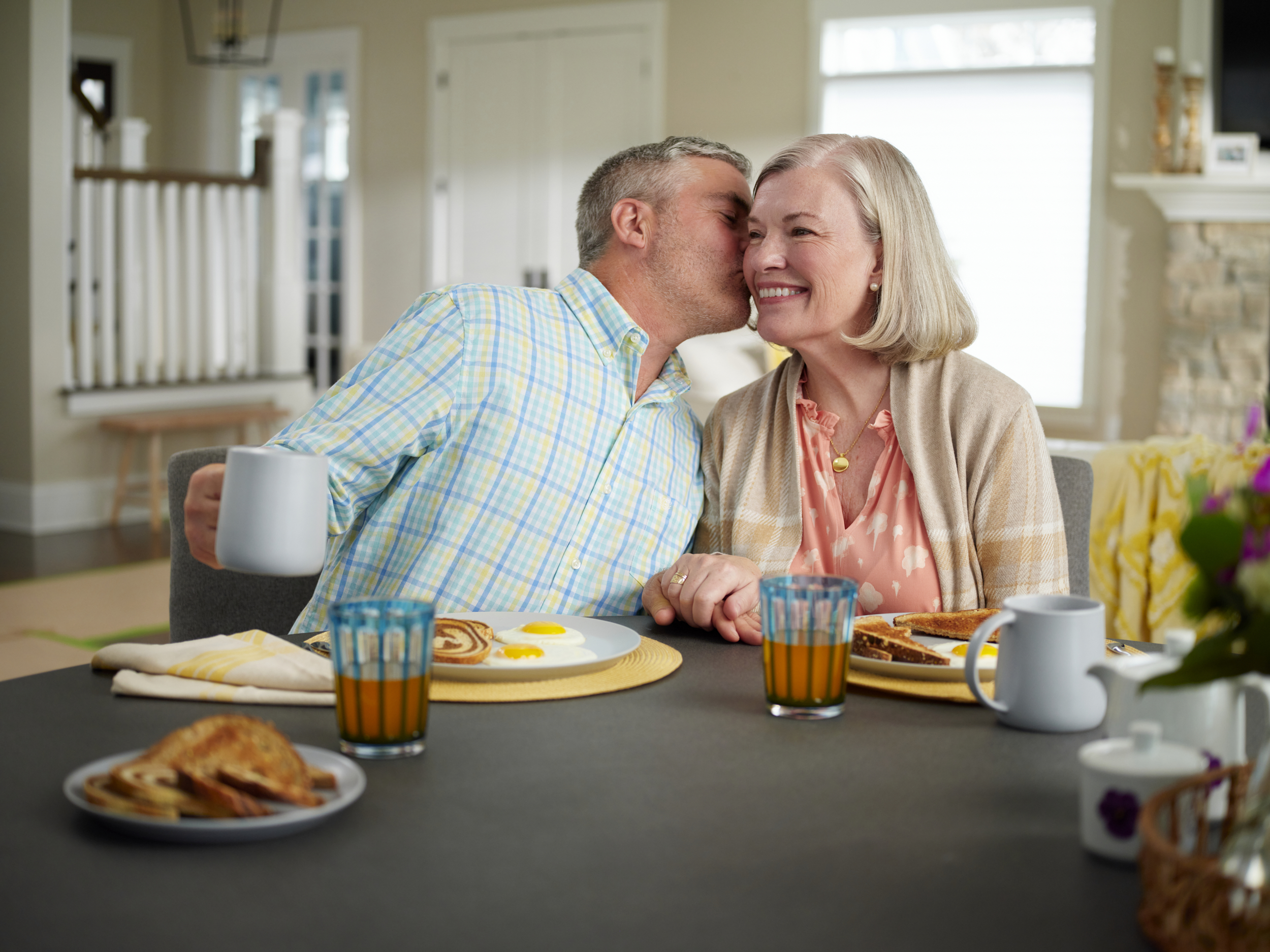 Senior couple sharing a kiss at breakfast